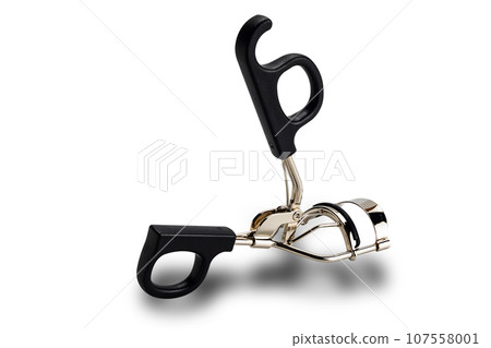 Side view of metal eyelash curler with black plastic handles isolated on white background. 107558001