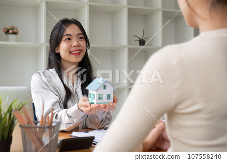 Real estate agent and client explain mortgage loan contract. Make a contract for hire purchase and sale of a house. home mortgage loan insurance concept. 107558240