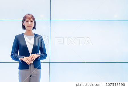 Business person standing in front of a huge display 107558390