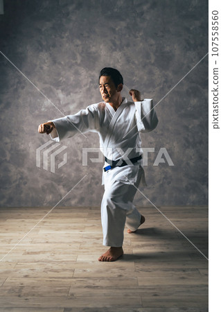 Middle-aged male martial artist wearing a gi Middle-aged male martial artist wearing a gi 107558560