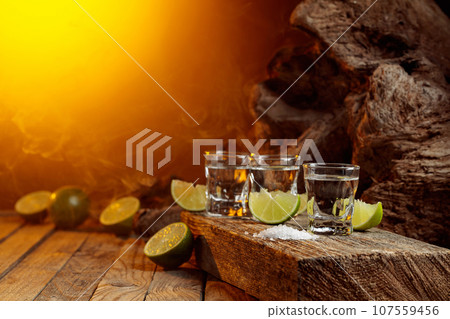 Tequila with salt and lime slices. Tequila with salt and lime slices. 107559456