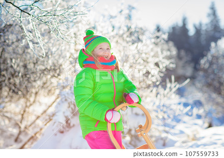 Baby boy on sled. Child sledding. Kid with sledge 107559733