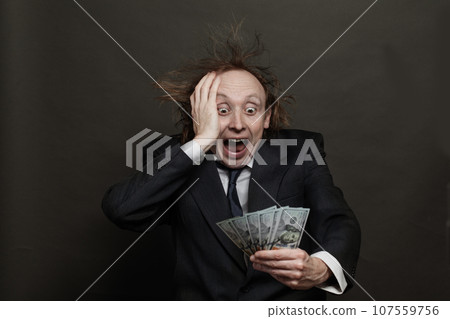 Businessman winner looking at American dollar cash money banknotes on black background Businessman winner looking at American dollar cash money banknotes on black background 107559756