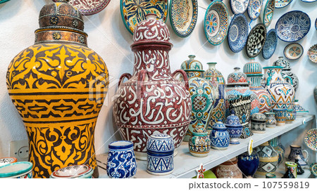 Moroccan pottery with colorful ceramics and pottery displayed outside shops in the souks, or traditional markets. Moroccan pottery with colorful ceramics and pottery displayed outside shops in the souks, or traditional markets. 107559819