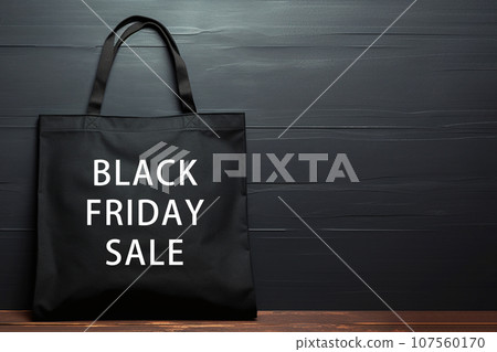 Black eco cotton tote bag on a black background with the inscription BLACK FRIDAY SALE. Sale season. Sale and shopping concept. Shopper design template for advertising, branding, mockup, copyspace 107560170
