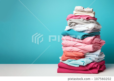 Pile of clothes ready for laundry. Stack of colorful clothes. Laundry day, fabric recycling concept. Fashion industry pollution, sustainability, up cycling, secondary clothing, reuse. Copy space 107560202