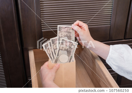 [一位家庭主婦將一張一萬日元的鈔票藏在抽屜裡的信封裡] 107560250