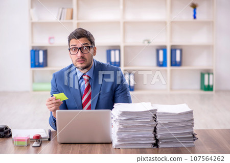 Young male employee unhappy with excessive work in the office 107564262