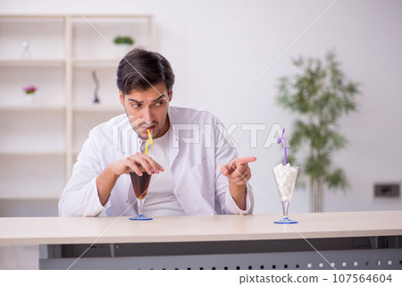 Young male chemist examining soft drink at the lab Young male chemist examining soft drink at the lab 107564604