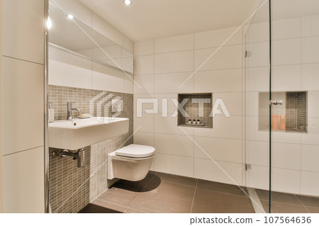 a bathroom with a toilet, sink and shower stall in the same room on the left side of the photo 107564636