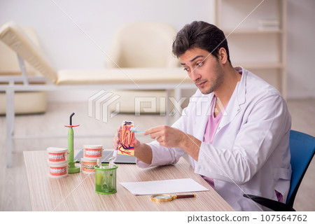 Young male dentist working in the clinic Young male dentist working in the clinic 107564762
