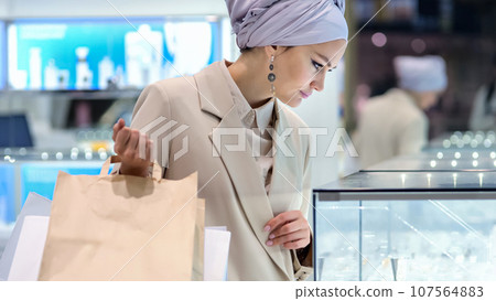 Muslim businesswoman with shopping bags in jewellery salon 107564883