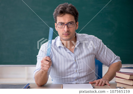Young male teacher in front of green board Young male teacher in front of green board 107565159