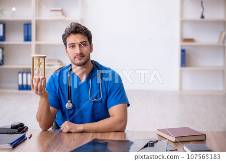 Young male doctor in time management concept Young male doctor in time management concept 107565183
