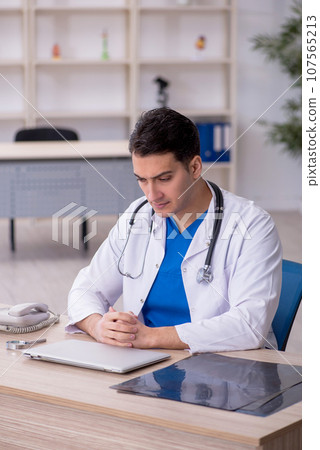Young male doctor sitting in the clinic 107565213