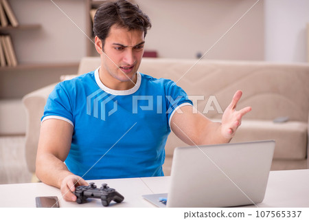 Young man playing video games at home 107565337