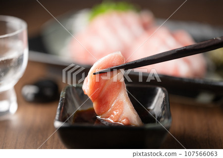 dipping blue fin fatty tuna slice into soy sauce dipping blue fin fatty tuna slice into soy sauce 107566063
