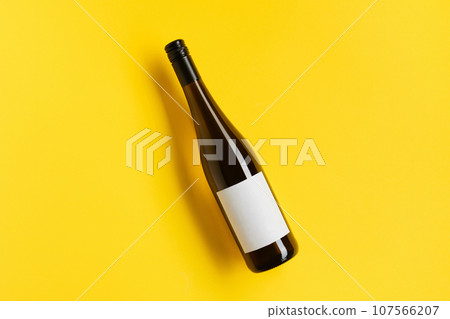 Wine bottle with blank label. Red wine on yellow background with copy space. 107566207