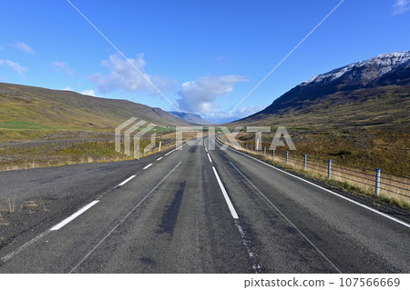 Ring Road in Iceland receding into distant curve under sunny autumn sky. 107566669