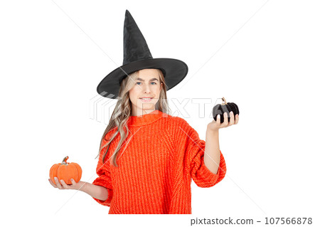 Halloween celebration concept. Portrait smiling girl in black hat, holding decorative pumpkins on white background. Halloween celebration concept. Portrait smiling girl in black hat, holding decorative pumpkins on white background. 107566878