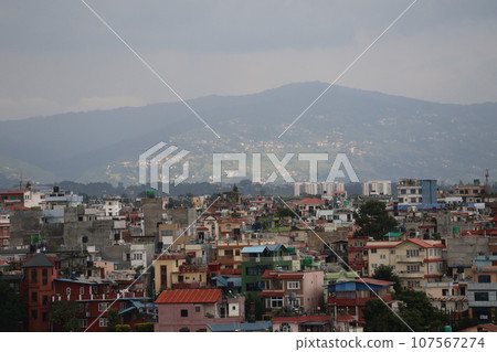 View of Kathmandu cityscape with mountains and colorful roofs and buildings from hotel room View of Kathmandu cityscape with mountains and colorful roofs and buildings from hotel room 107567274