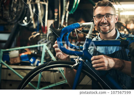 Portrait, smile and repair man working in bicycle shop, store and cycling workshop from Canada with glasses. Face, bike mechanic and confident male person, professional and happy mature technician 107567599