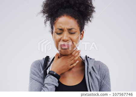 Black woman, sore throat and virus from cough, allergies or bacteria against a white studio background. Sick African female person touching neck in pain, allergy or flu of cold, illness or infection Black woman, sore throat and virus from cough, allergies or bacteria against a white studio background. Sick African female person touching neck in pain, allergy or flu of cold, illness or infection 107567746