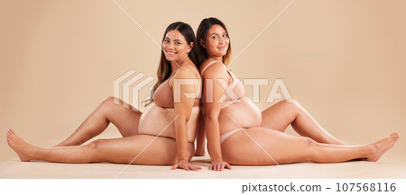 Friends, pregnancy and studio portrait for underwear, smile and women sitting together for support on floor. Happy future mom, pregnant or solidarity for health, love or healthy stomach by background 107568116