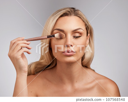 You are imperfect, permanently and inevitably flawed. Studio shot of a beautiful young woman holding a makeup brushe against a grey background. You are imperfect, permanently and inevitably flawed. Studio shot of a beautiful young woman holding a makeup brushe against a grey background. 107568548