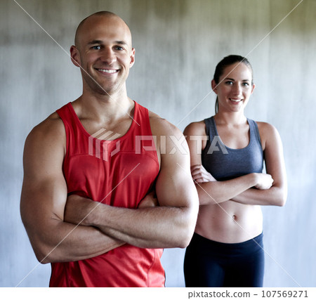 Happy people, fitness and portrait smile with arms crossed in confidence for workout, exercise or training at gym. Strong, fit or confident man or woman personal trainer ready for exercising together Happy people, fitness and portrait smile with arms crossed in confidence for workout, exercise or training at gym. Strong, fit or confident man or woman personal trainer ready for exercising together 107569271