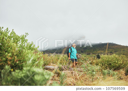 Old man, hiking with nature and exercise, travel and walking in field or bush for health and wellness outdoor. Adventure, trekking and fitness, mockup space and freedom with retirement activity 107569509
