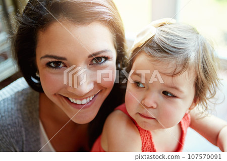 Happy, playful and portrait of a mother with a baby for bonding, quality time and relaxation. Smile, happiness and face of a mom playing with a child for care, comfort and carefree parenthood 107570091