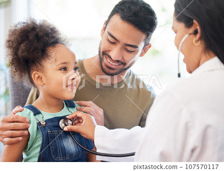 Shes very healthy, dad. Shot of a little girl sitting on her fathers lap while being examined by her doctor. Shes very healthy, dad. Shot of a little girl sitting on her fathers lap while being examined by her doctor. 107570117