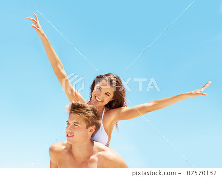 Piggyback, freedom and a couple at the beach in summer for bonding, holiday or an ocean date. Smile, love and a man and woman being playful at the sea for a vacation, happiness or travel in Bali 107570132