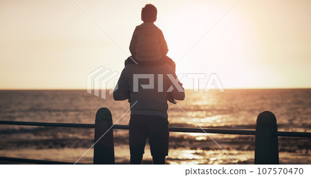 Father, child and back in sunset by the ocean for family bonding, playing or fun holiday or weekend in nature. Dad carrying kid on piggyback by beach coast enjoying sunrise or travel together outdoor Father, child and back in sunset by the ocean for family bonding, playing or fun holiday or weekend in nature. Dad carrying kid on piggyback by beach coast enjoying sunrise or travel together outdoor 107570470