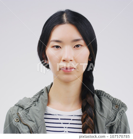 Face, serious portrait and asian woman in studio with concentration and focus. Headshot of a young female student or natural model from Japan with casual clothes isolated on a white background 107570785