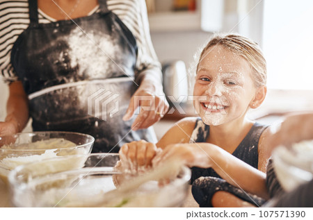 Flour, playing or portrait of girl baking in kitchen with a messy young kid smiling with a dirty face at home. Smile, happy or parent cooking or teaching a fun daughter to bake for child development 107571390