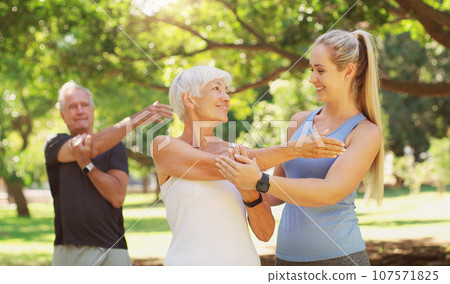 Yoga, workout and an old couple with their personal trainer in a park for a health or active lifestyle. Exercise, wellness or zen and senior people outdoor for fitness class with their pilates coach Yoga, workout and an old couple with their personal trainer in a park for a health or active lifestyle. Exercise, wellness or zen and senior people outdoor for fitness class with their pilates coach 107571825