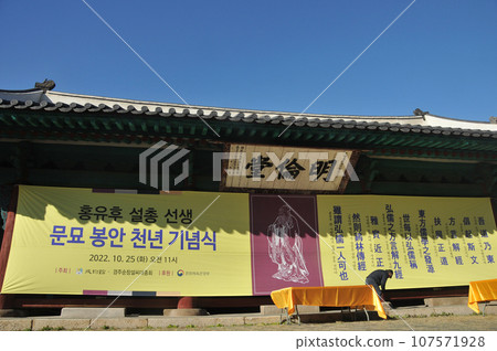 Poster of Confucius festival at Myeongryundang lecture hall of Sungkyunkwan University in Autumn. There is a construction worker pulls the poster. 107571928