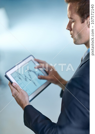 Lets see what the figures tell us. Cropped image of a businessman holding a digital tablet. Lets see what the figures tell us. Cropped image of a businessman holding a digital tablet. 107572140