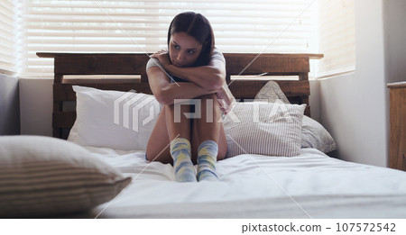 Depression, stress and woman in a bed thinking of problem, sad or mental health in her home. Anxiety, fear and female person with ptsd, grief or broken heart, lonely and paranoid in a bedroom 107572542
