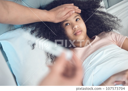 Praying its a common cold. Shot of an unrecognizable man taking his daughters temperature at home. 107573704