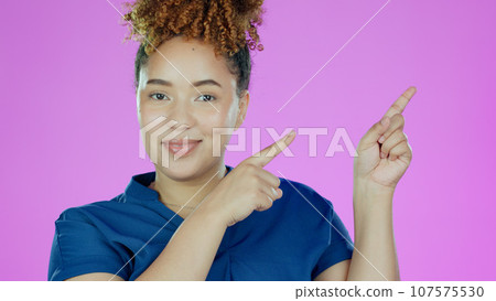 Woman, portrait and pointing at information for advertising, announcement or offer with smile on pink background. Direction, marketing and news with opportunity, mockup with promo or advice in studio 107575530