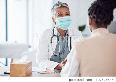 Face mask, mature or doctor consulting a patient in meeting in hospital writing history or healthcare record. People, medical or happy nurse with woman talking or speaking of test results or advice 107575627