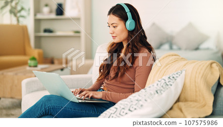 Online work, internet music and woman listening to an audio podcast while typing an email on the living room sofa of house. Remote entrepreneur working on laptop with radio on the web on the couch Online work, internet music and woman listening to an audio podcast while typing an email on the living room sofa of house. Remote entrepreneur working on laptop with radio on the web on the couch 107575986
