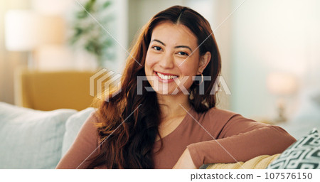 Serious woman, relax and home with a beautiful asian female feeling calm, peaceful and enjoying her free time on the sofa at home. Portrait and face of a young female sitting in her singapore house 107576150