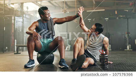 Happy man, high five and fitness in sports motivation, teamwork or partnership at the gym. People touching hands in workout, exercise or training together for physical health or wellness at gymnasium Happy man, high five and fitness in sports motivation, teamwork or partnership at the gym. People touching hands in workout, exercise or training together for physical health or wellness at gymnasium 107576366