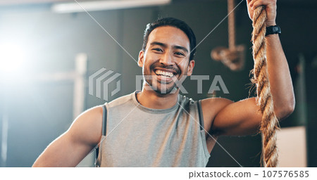 Fitness, gym and face of man with rope for training, bodybuilder exercise and intense workout. Sport, personal trainer and portrait of happy person with equipment for wellness, performance and muscle Fitness, gym and face of man with rope for training, bodybuilder exercise and intense workout. Sport, personal trainer and portrait of happy person with equipment for wellness, performance and muscle 107576585