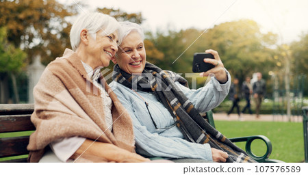 Senior, women and selfie in a park happy, bond and relax in nature on a bench together. Friends, old people and ladies smile for social media, profile picture or memory in forest chilling on weekend 107576589