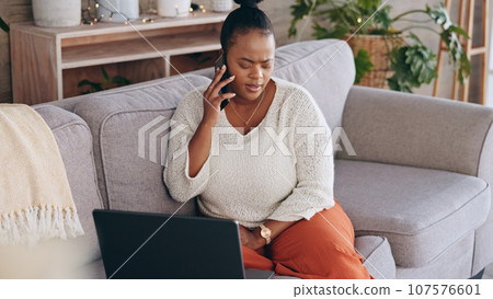 Laptop, phone call and worry with a black woman on a sofa in the living room of her home for problem solving. Computer, communication and a concerned person talking on her mobile for networking Laptop, phone call and worry with a black woman on a sofa in the living room of her home for problem solving. Computer, communication and a concerned person talking on her mobile for networking 107576601